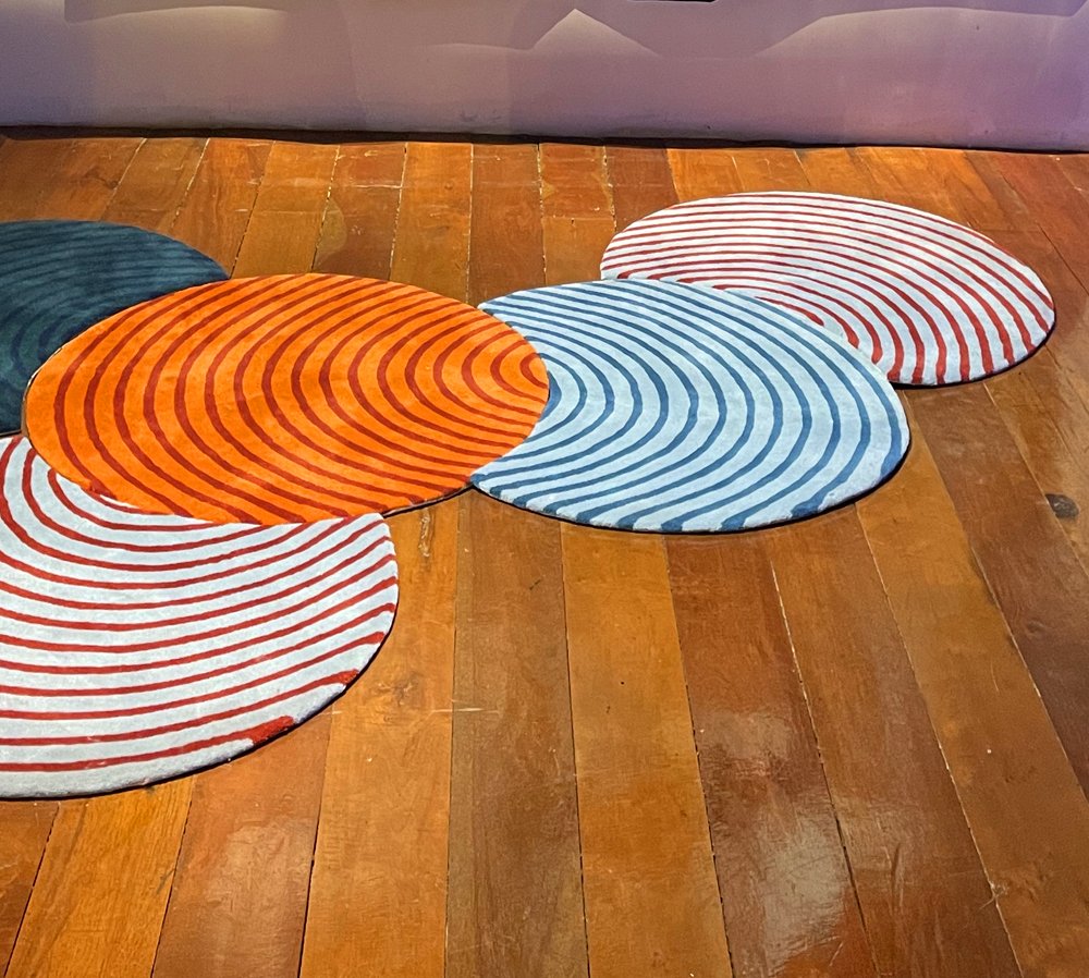circular striped rugs on display