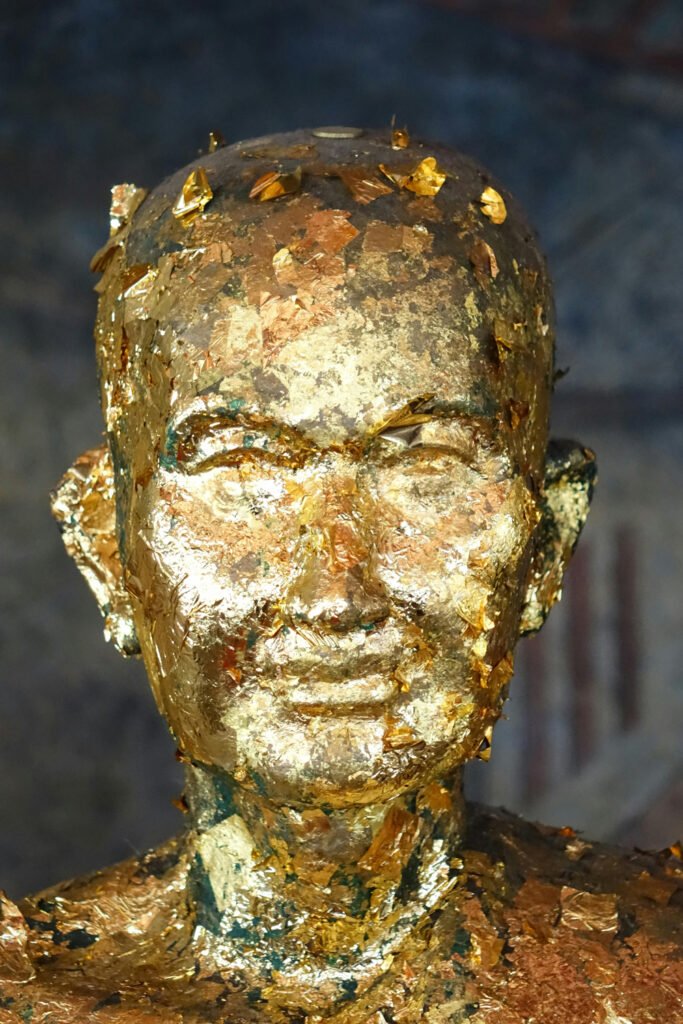 a golden head bust sculpture of a monk