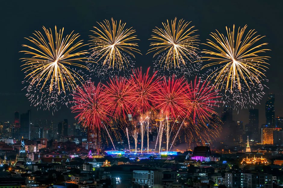 Fireworks in Bangkok with reflections on the Chao Phraya River during New Year celebrations.