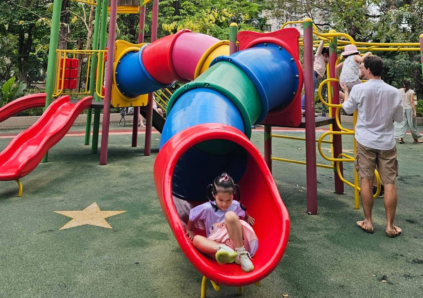 girl sliding down slide at the playground at Benjasiri Park
