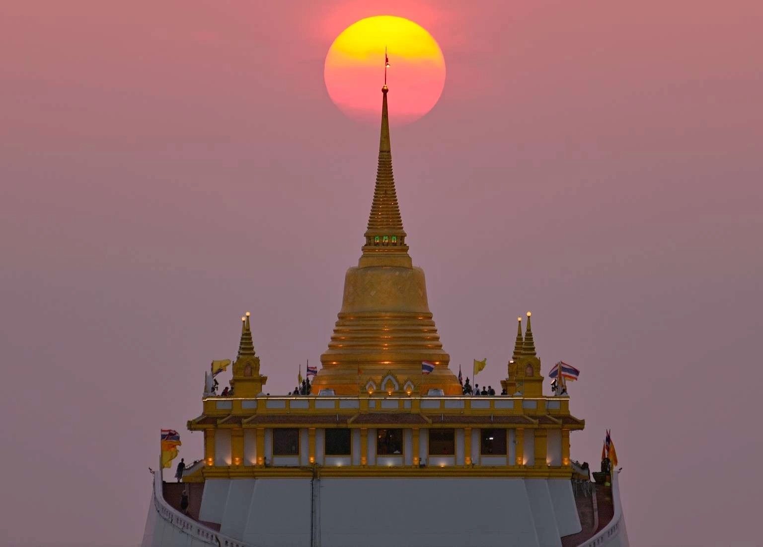 sun setting behind Wat Saket Golden Mount