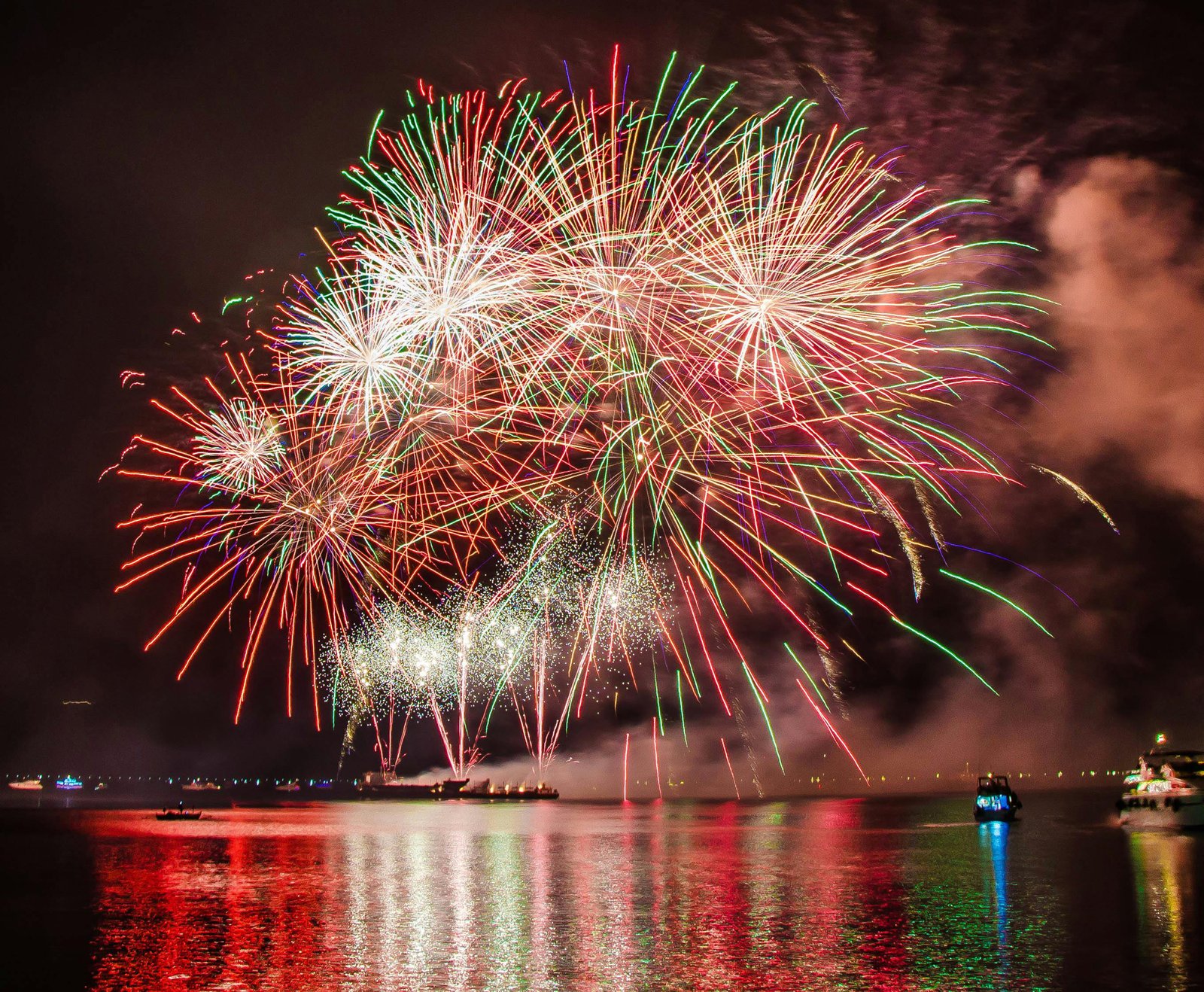 fireworks on chao phraya river in bangkok reflecting off of the river.