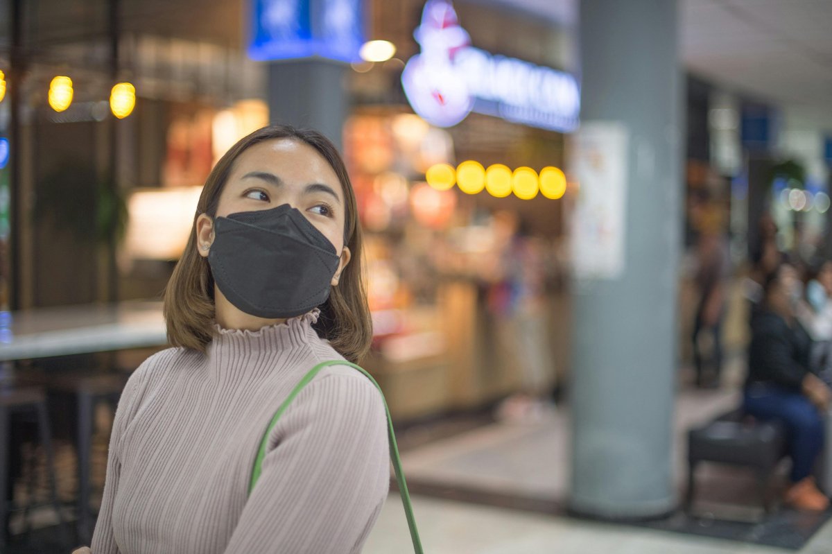 Woman with mask on walking in a mall in Bangkok