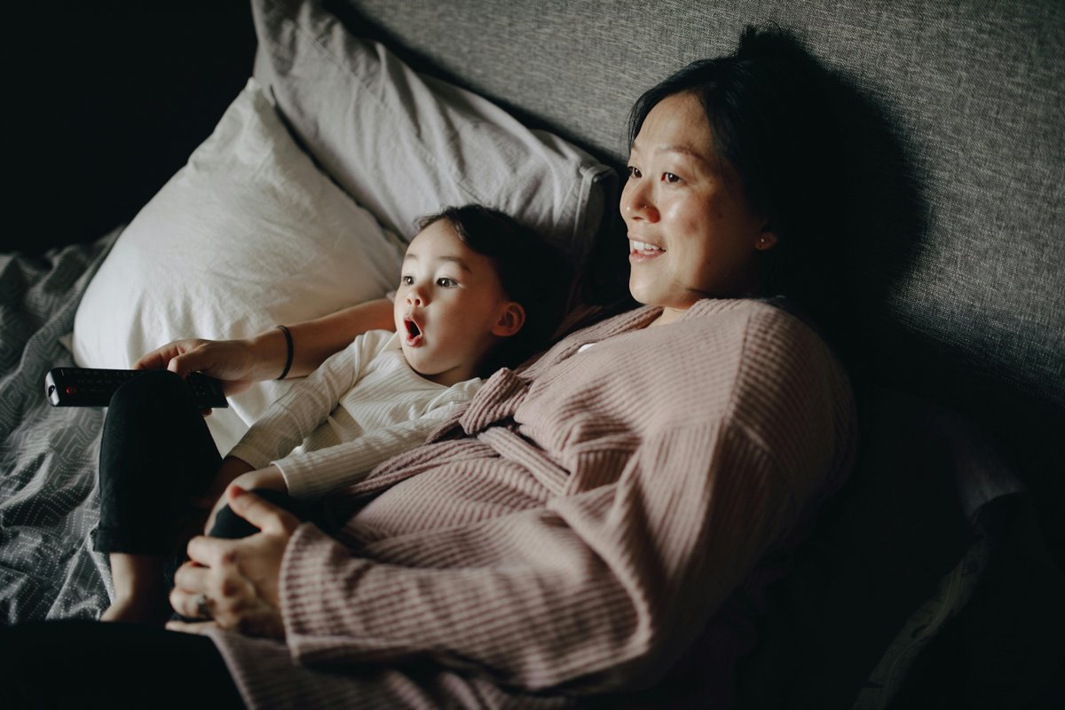 mom and baby watching tv on the bed