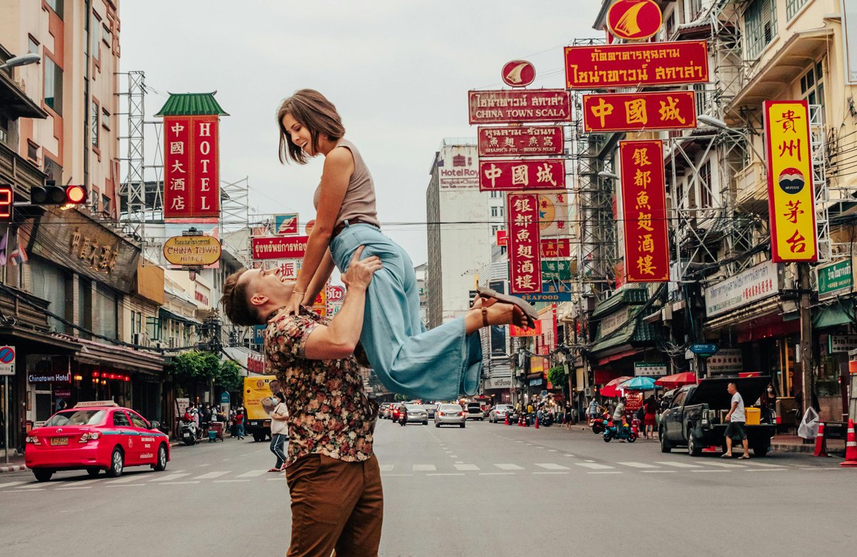 Man lifting woman up in the air in Chinatown