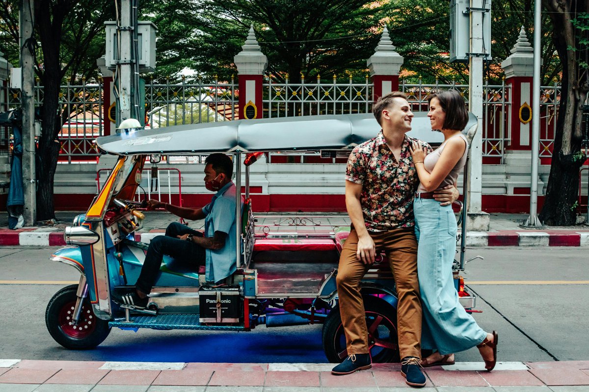 couple standing next to a tuk tuk