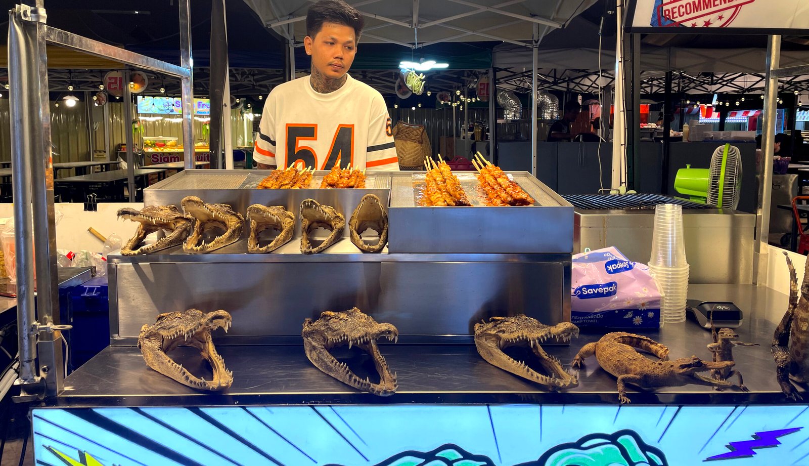 man selling alligator at night market ratchada